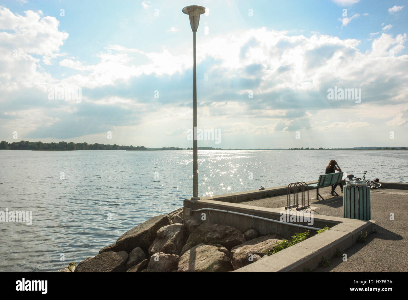 girl sitting on the side of a river Stock Photo - Alamy
