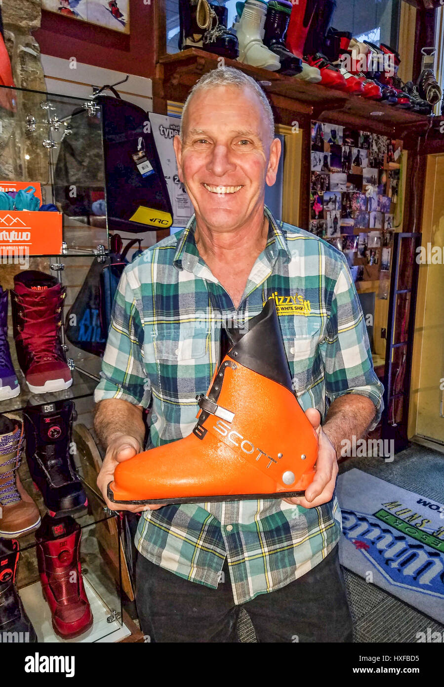 Dizzy of Dizzy's boot fitting shop at Big White ski resort shows off an early 1970s ski boot that boasted fantastic ski technology that, sadly, was ah Stock Photo
