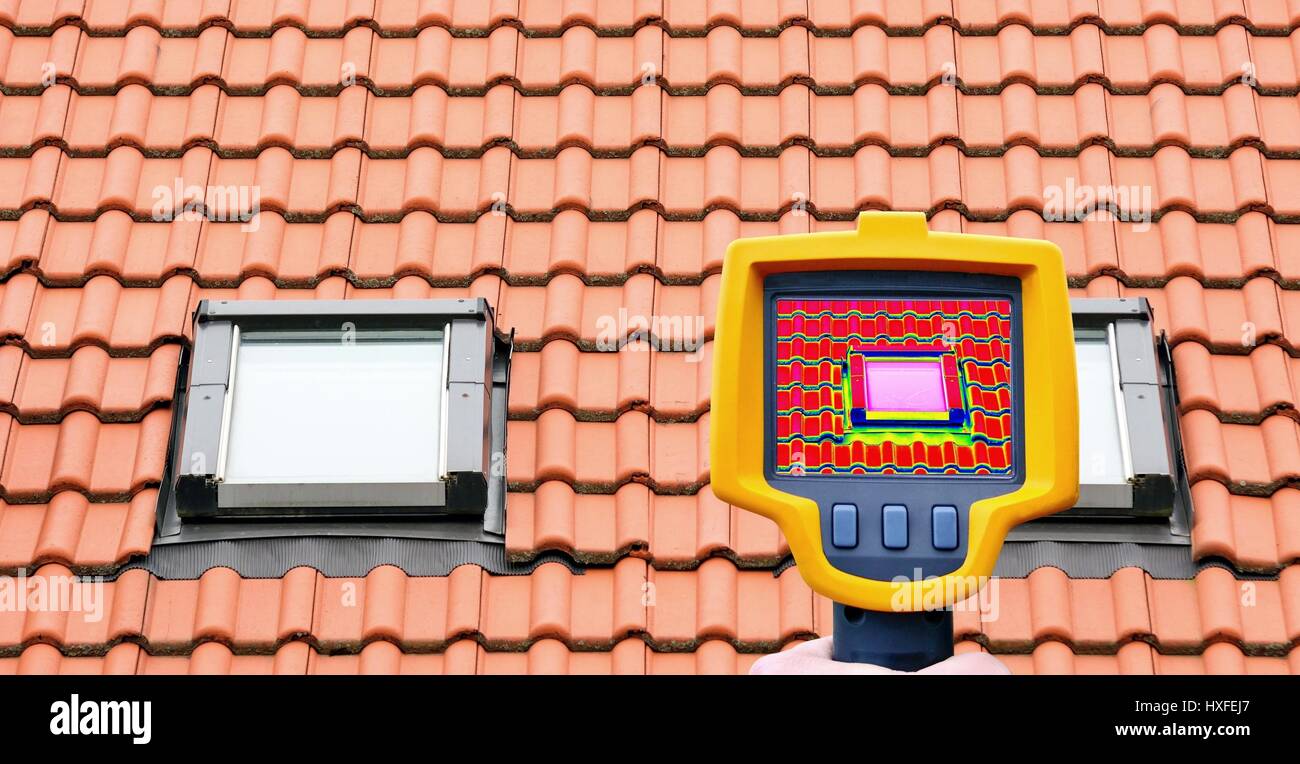 An infrared thermal imager showing roof window heat loss. Stock Photo