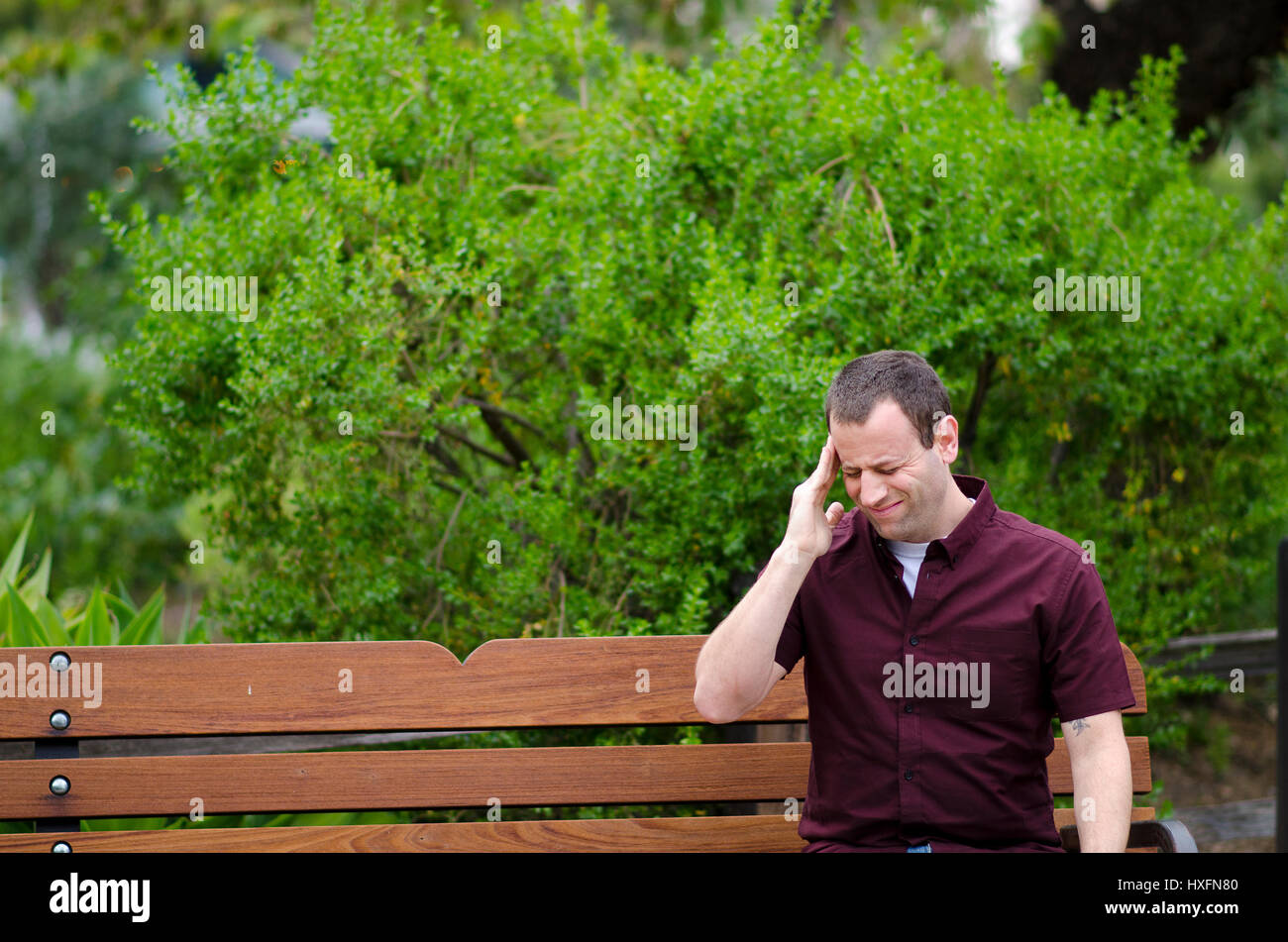 Stressed out man with a headache with his hand on his temple. Stock Photo