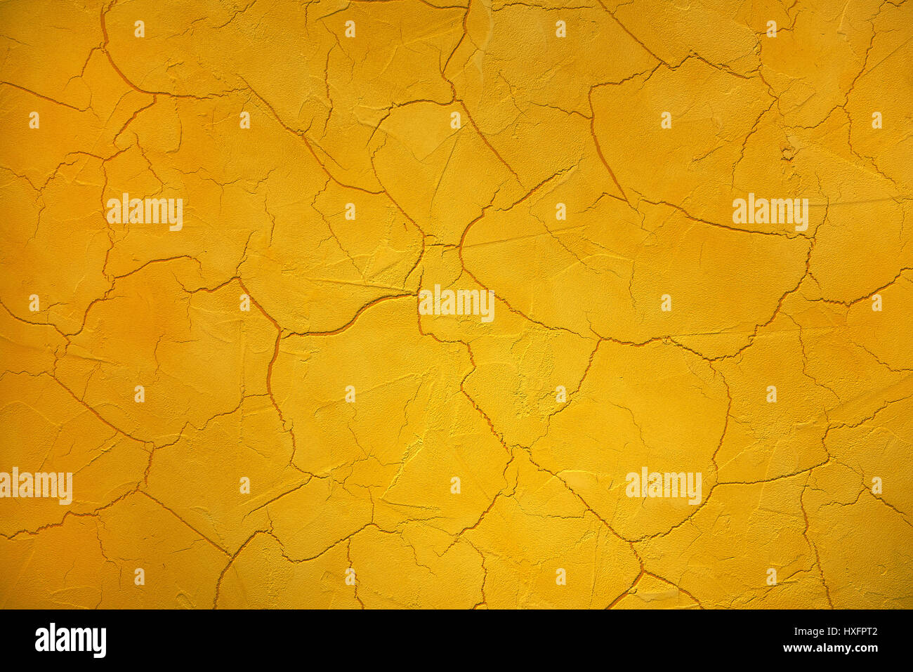 Crackle or cracked paint full frame background texture in bright yellow