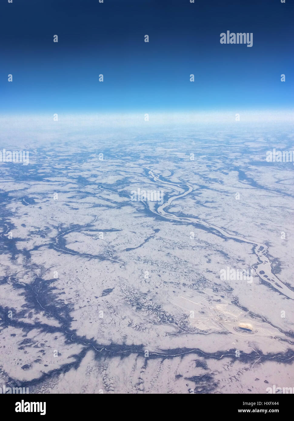 Aerial view of Northern Canada taken from flight over the vast expanse of frozen rivers and snowy landscape Stock Photo
