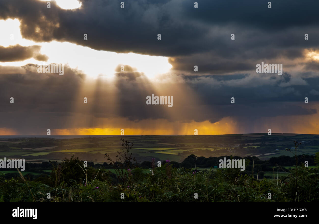 Just before sunset. Light rays shining through the stormy clouds and hitting Bodmin Moor, Cornwall, down below. Stock Photo