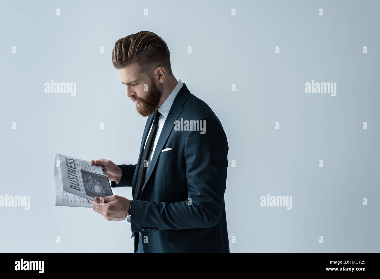 Stylish bearded businessman reading newspaper on grey Stock Photo - Alamy