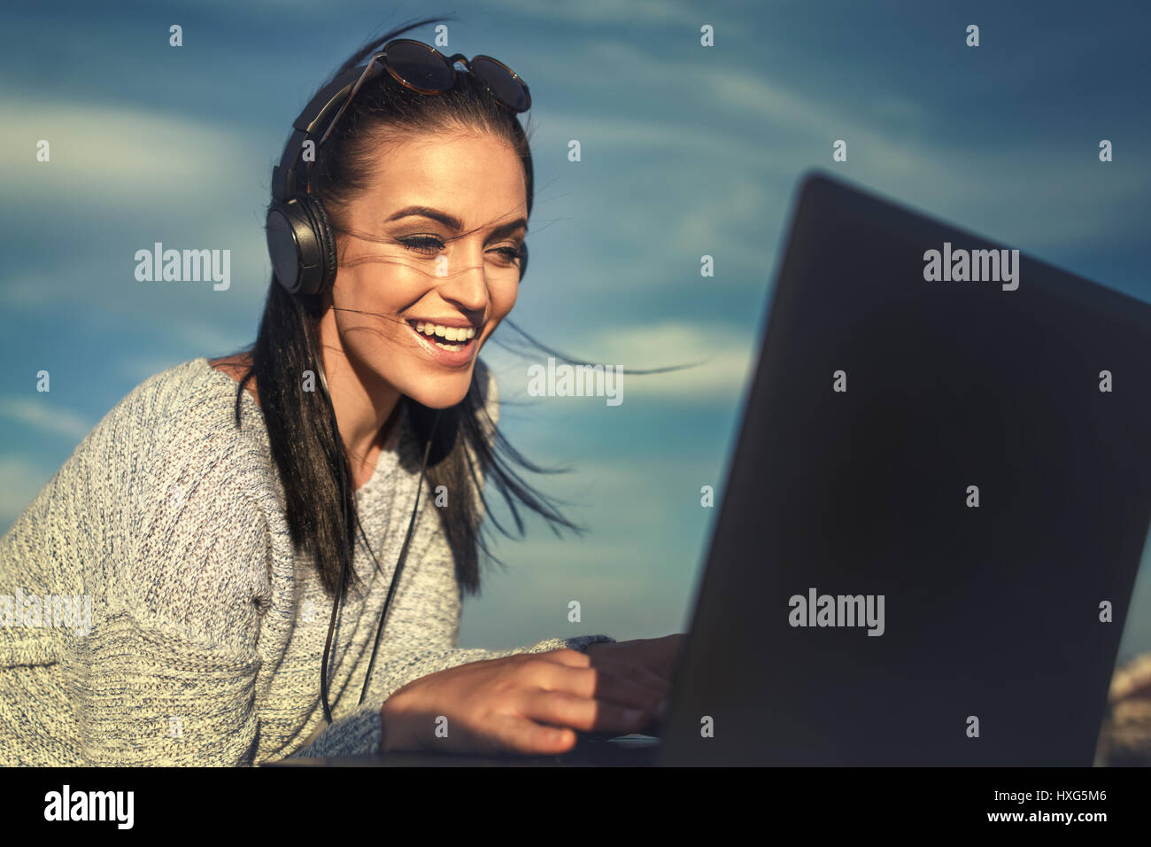 Smiling businesswoman working with laptop outdoor Stock Photo