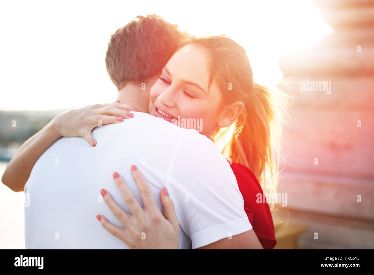 Young blonde woman embracing boyfriend outdoor Stock Photo