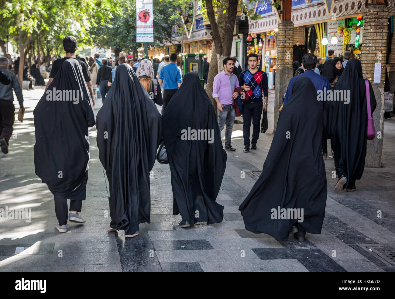 Women wearing chadors on the street next to Grand Bazaar in Tehran city, capital of Iran and Tehran Province Stock Photo