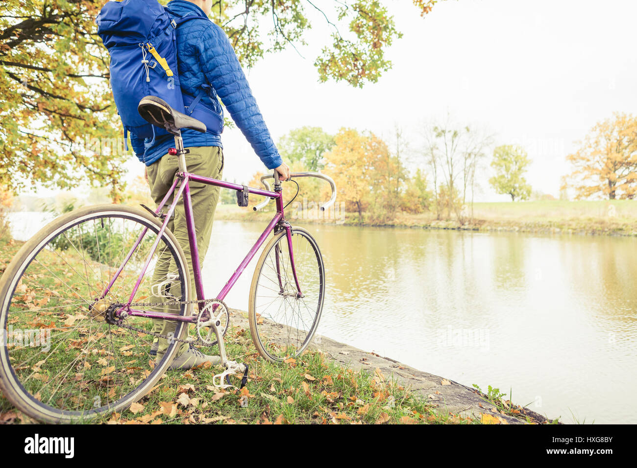 Man with road bike looking at river view in park. Male commuter and fixed gear bicycle relaxing in green park. Sport fitness motivation and inspiratio Stock Photo