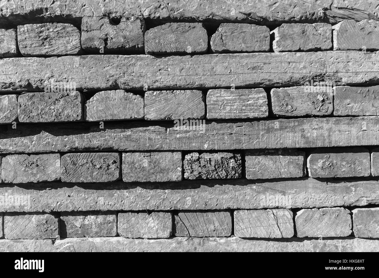 Wood beams track railway sleepers stacked closeup abstract black and white background textures detail. Stock Photo