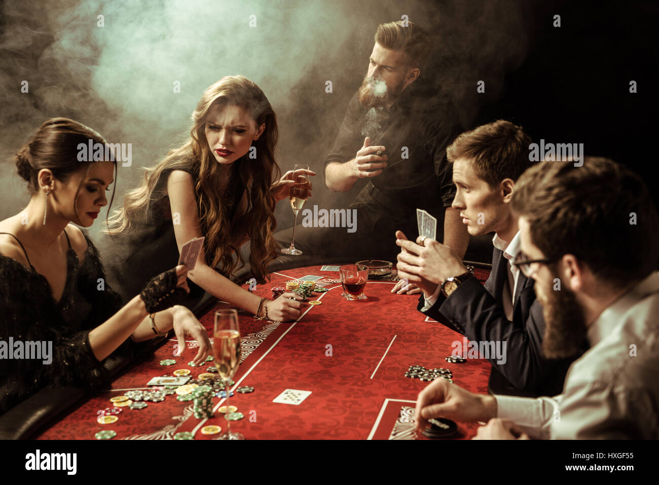 side view of people playing poker together in casino Stock Photo