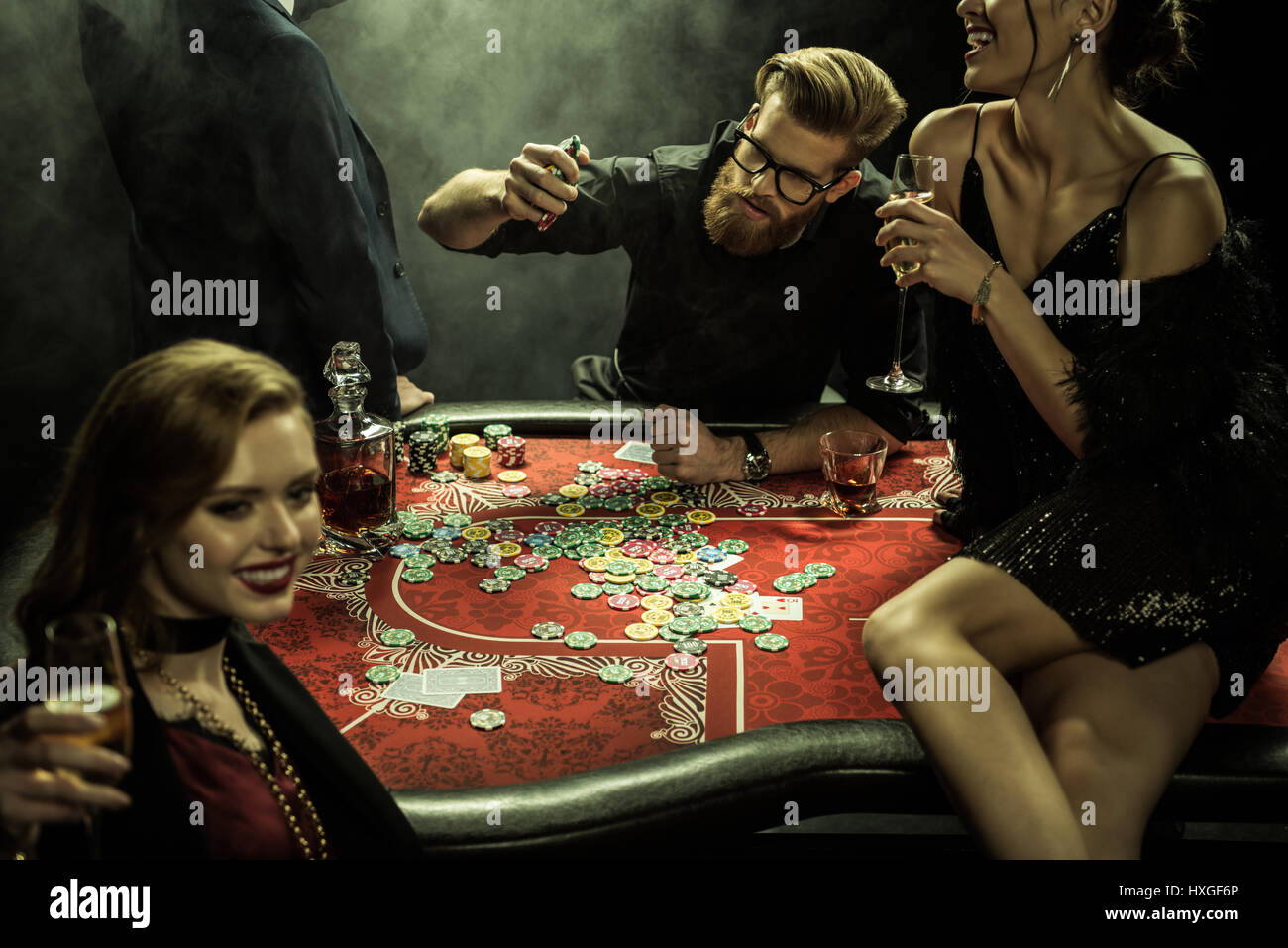 side view of group of people playing poker together in casino Stock Photo