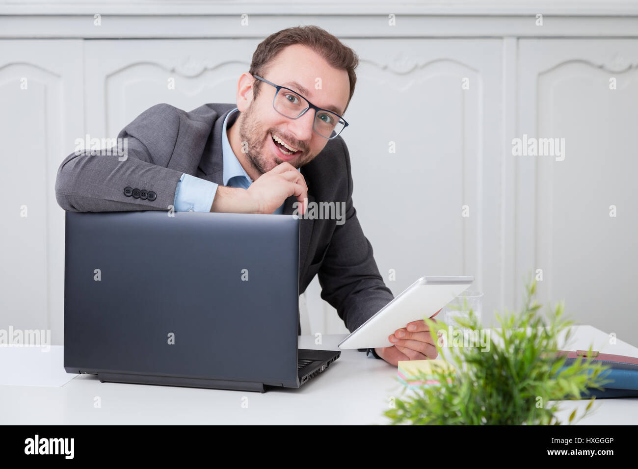 Happy businessman at the office desk Stock Photo