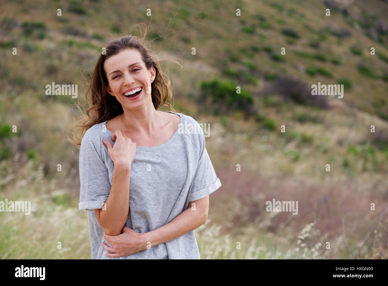 Portrait of older woman laughing in field Stock Photo - Alamy