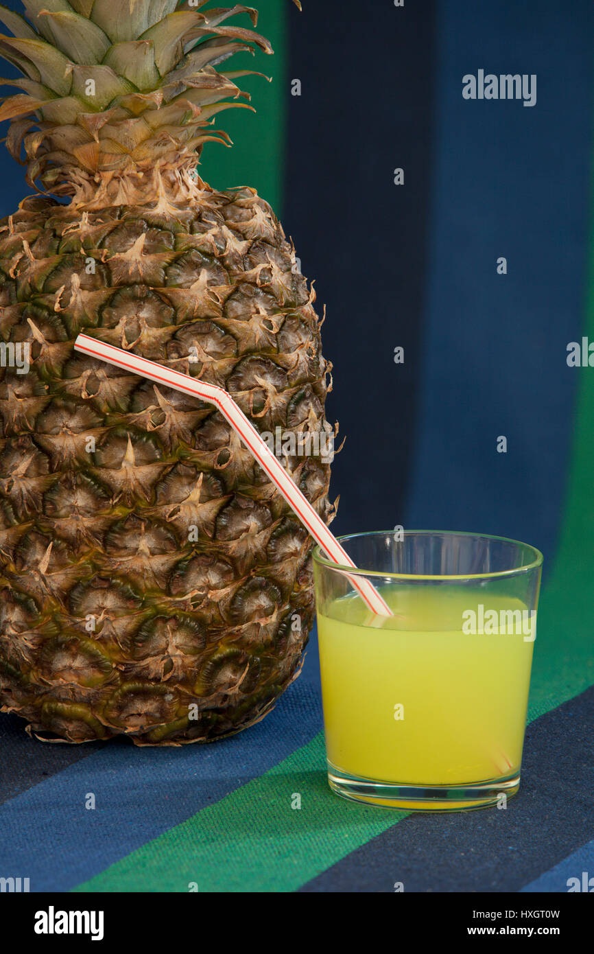 glass of juice with a straw near Pineapple Stock Photo - Alamy