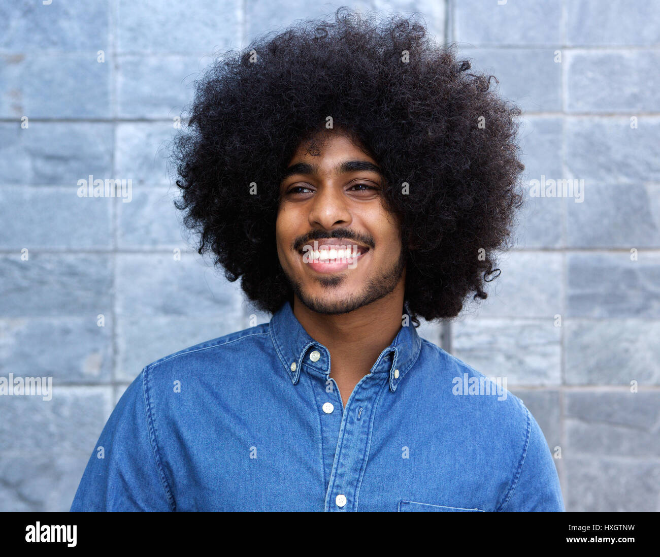 Close up portrait of a cool young black guy smiling with afro Stock Photo -  Alamy
