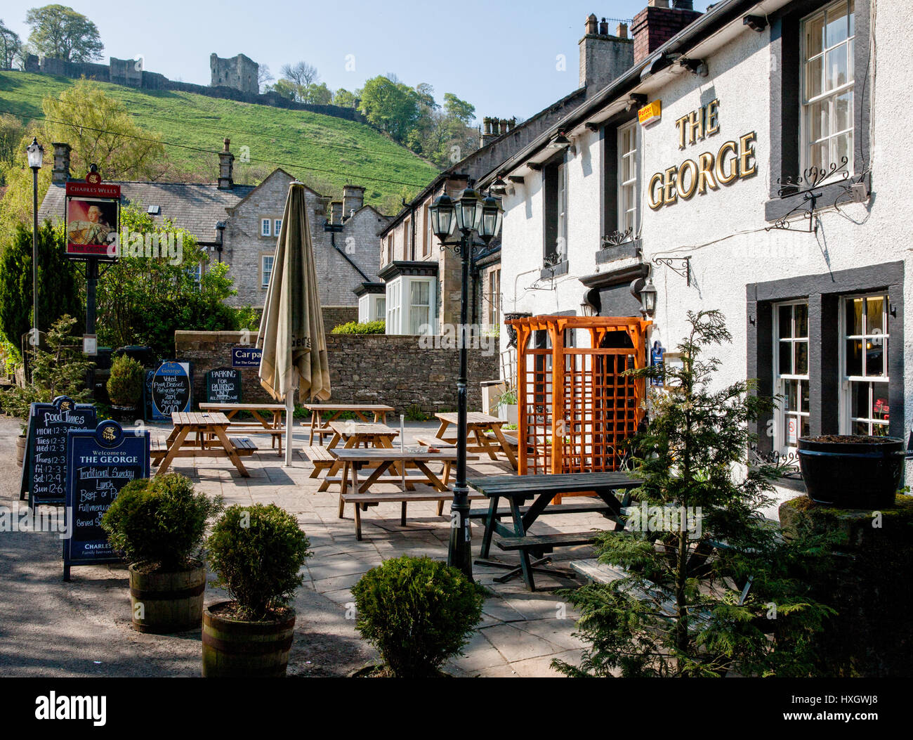 The George Inn at Castleton in the derbyshire Peak District with Peveril Castle on the hill behind the village Stock Photo