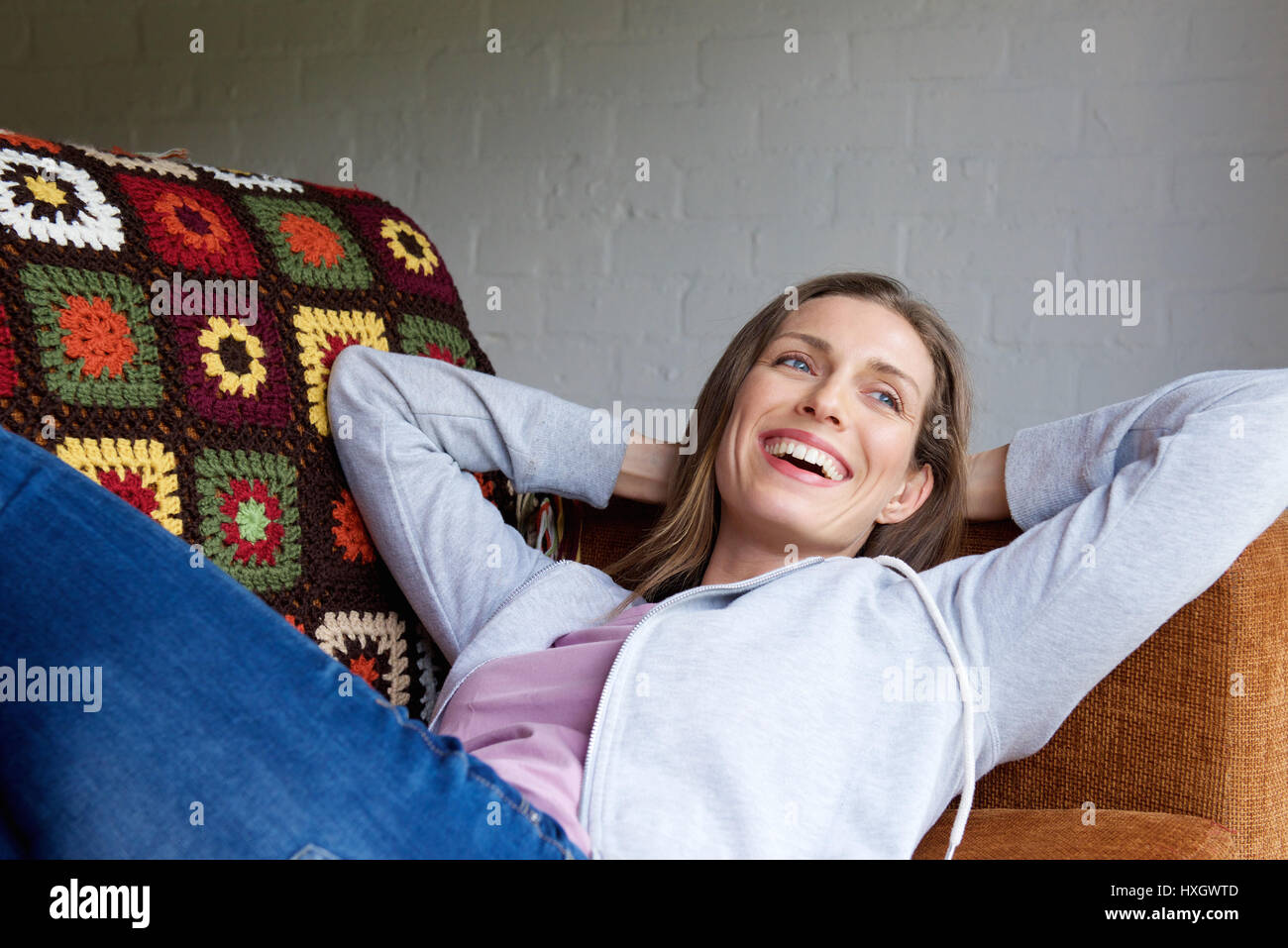 Portrait of a smiling older woman lying down on couch Stock Photo - Alamy