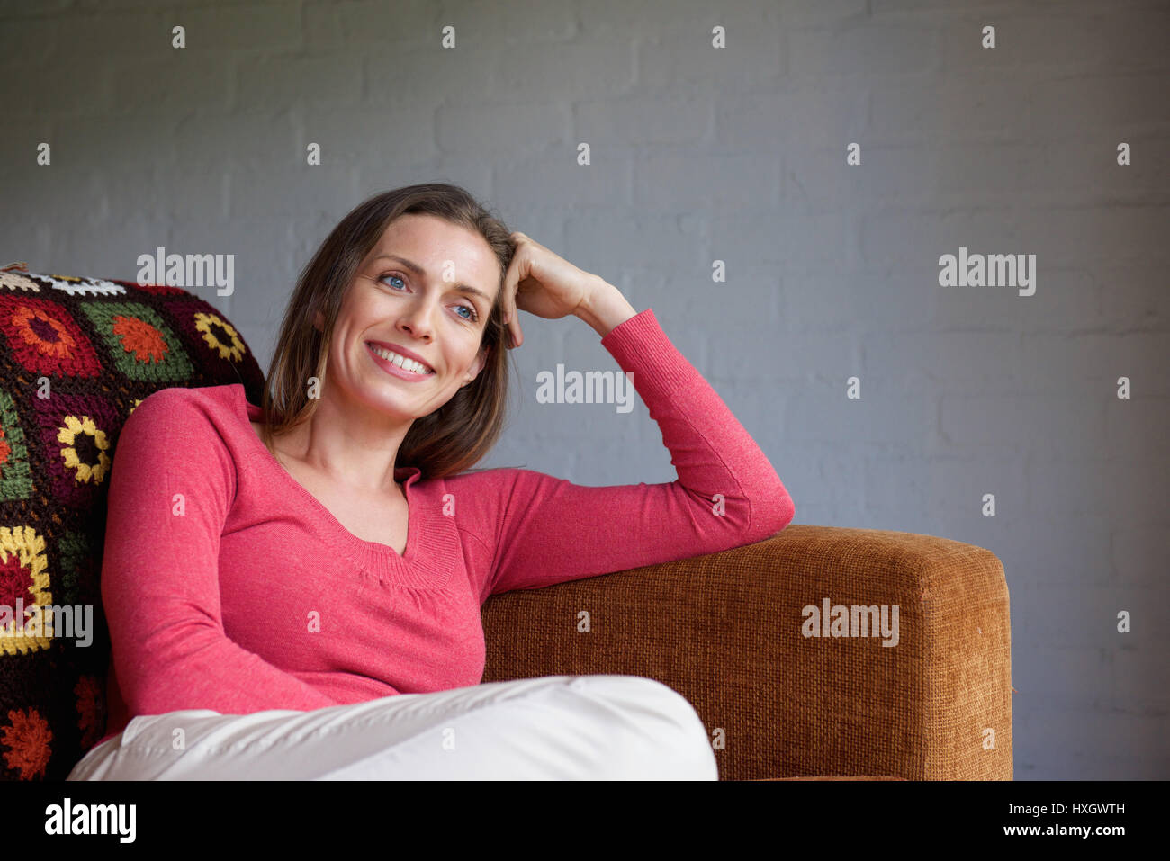 Portrait of a smiling older woman relaxing on couch Stock Photo - Alamy