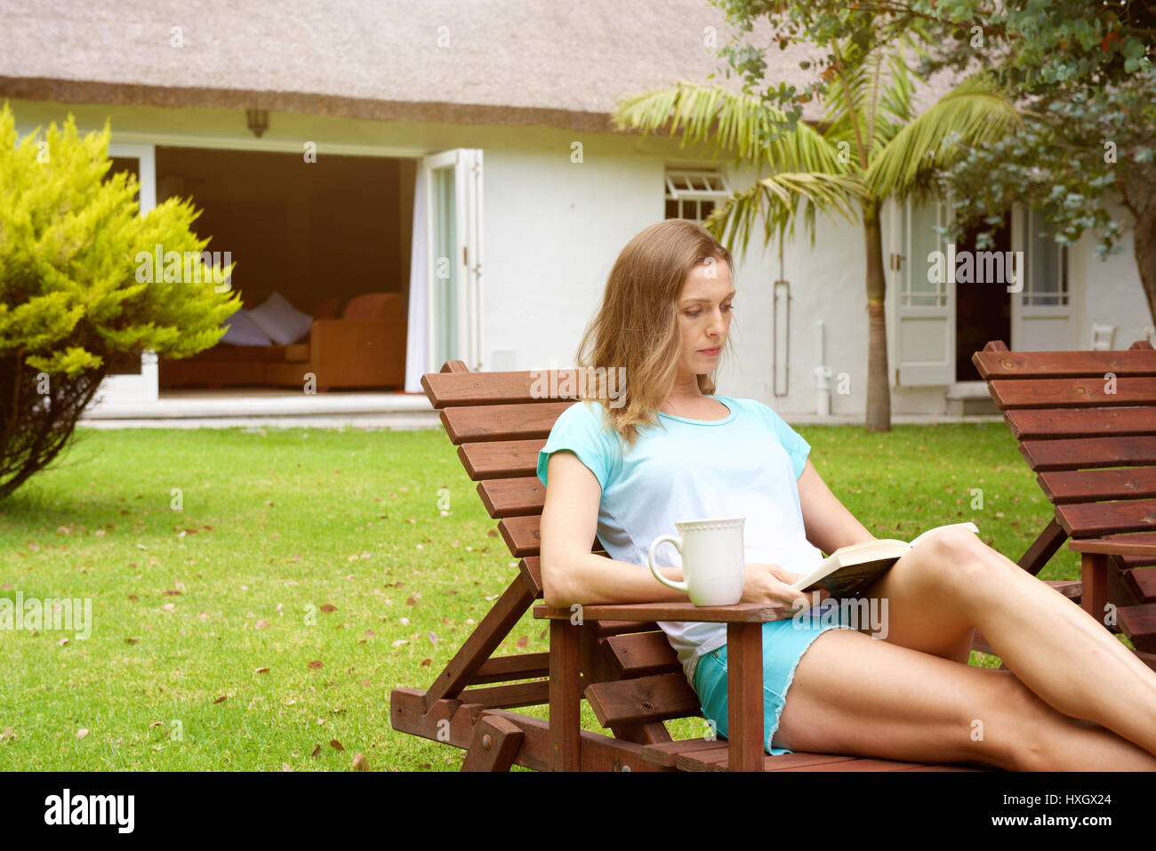Portrait of an older woman relaxing in home garden with book Stock ...