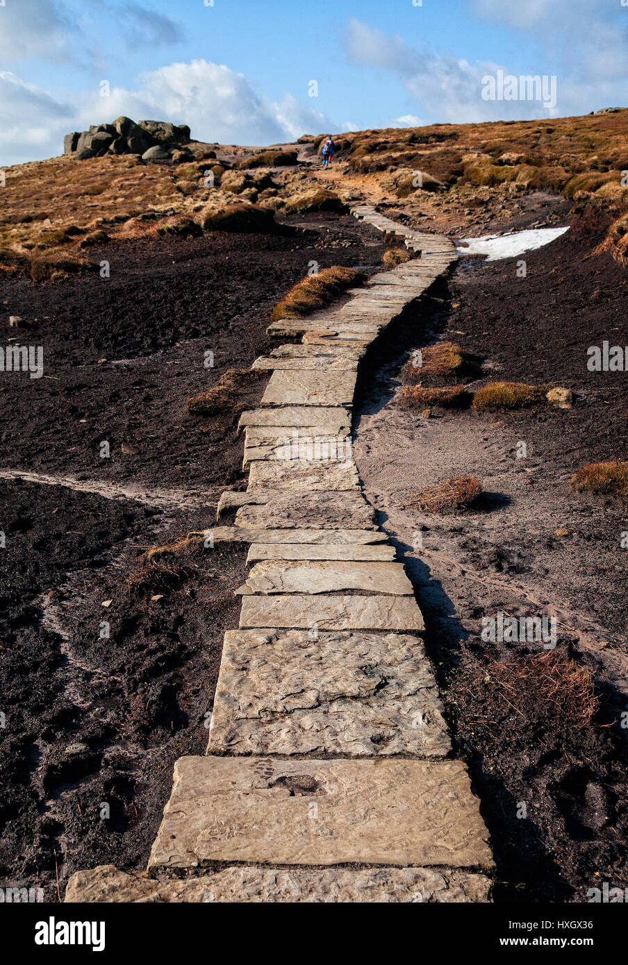 Flagstone path laid across exposed peat to reduce erosion from walkers on the plateau of kinder Scout in the Derbyshire Peak District UK Stock Photo
