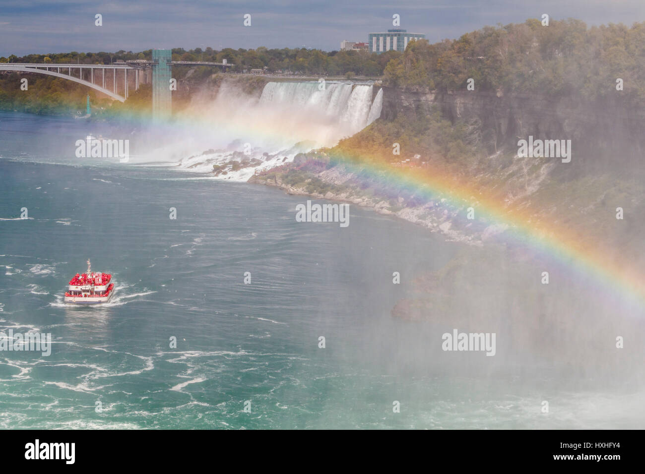 The Rainbow Bridge adjoining New York State and Ontario, complete with rainbow and the Niagara Wonder adventure boat, and American Falls, Canada. Stock Photo