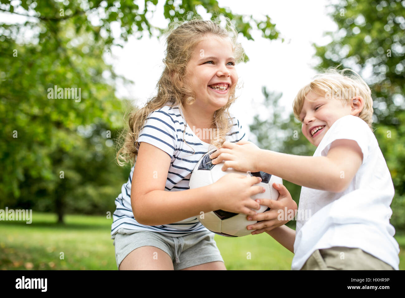 Controversy between children and a ball during family soccer match Stock Photo