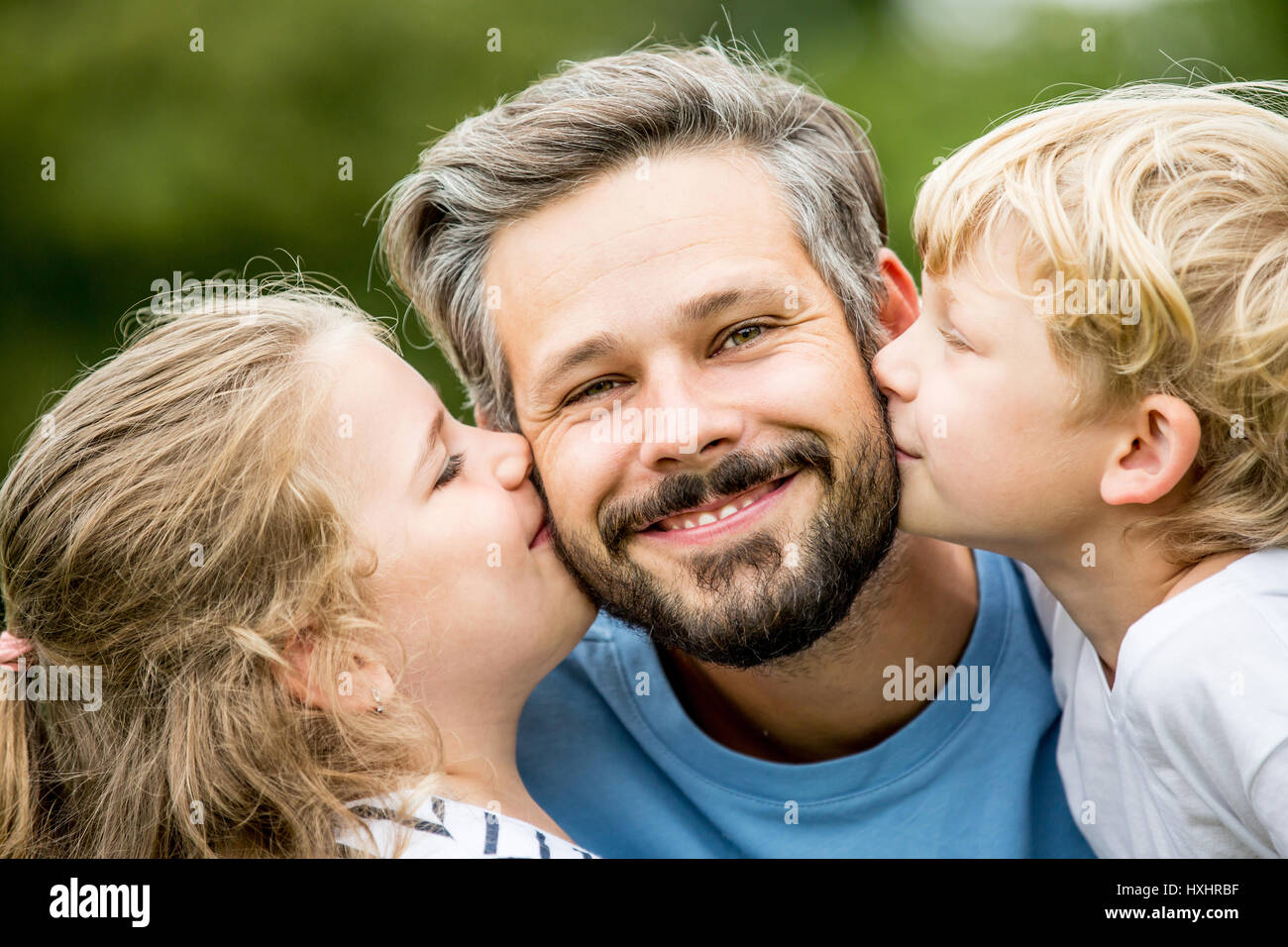 Single father kissed by children with love as a family Stock Photo