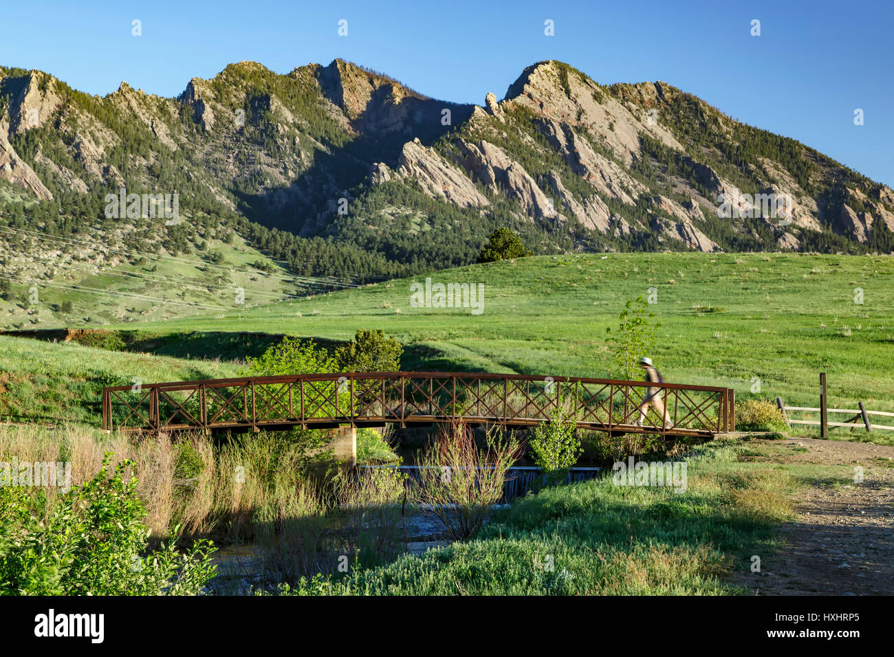 Hiker going over bridge, Flatirons in background, Boulder, Colorado USA Stock Photo Alamy