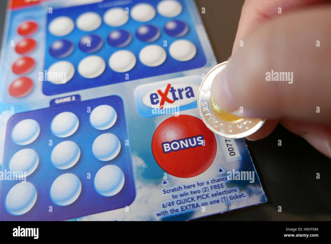 Coquitlam BC Canada - November 20, 2016 : Woman scratching lottery ticket on bonus section. The British Columbia Lottery Corporation has provided gove Stock Photo