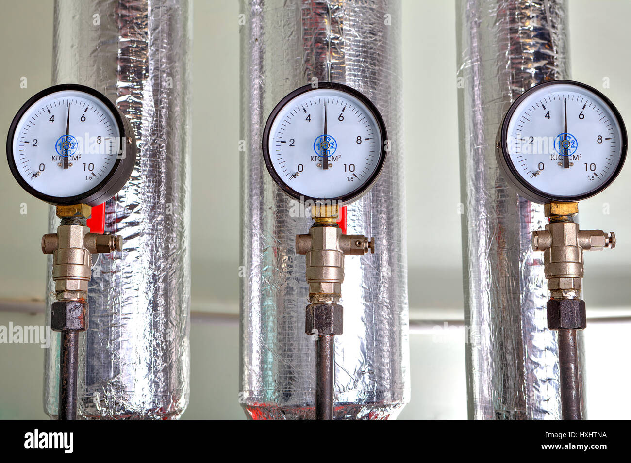 Gauges in the boiler room near the heating pipes with insulation