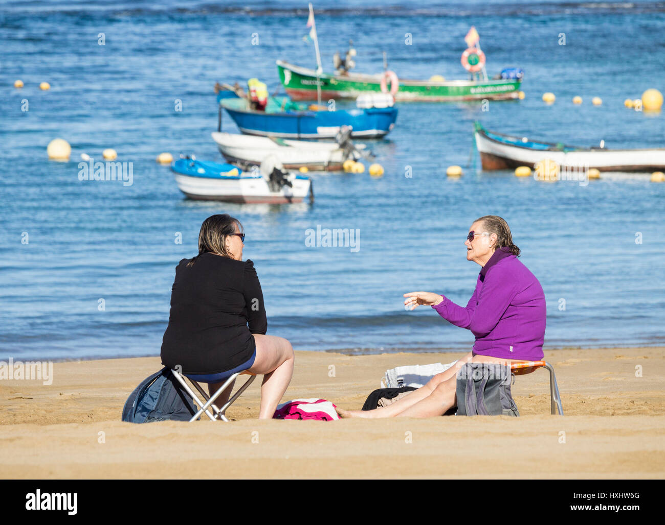 Two elderly women talking on beach following morning swim Stock Photo