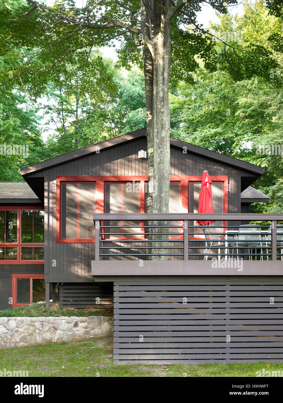 Exterior with deck around maple tree. Campbell House, Honor, United