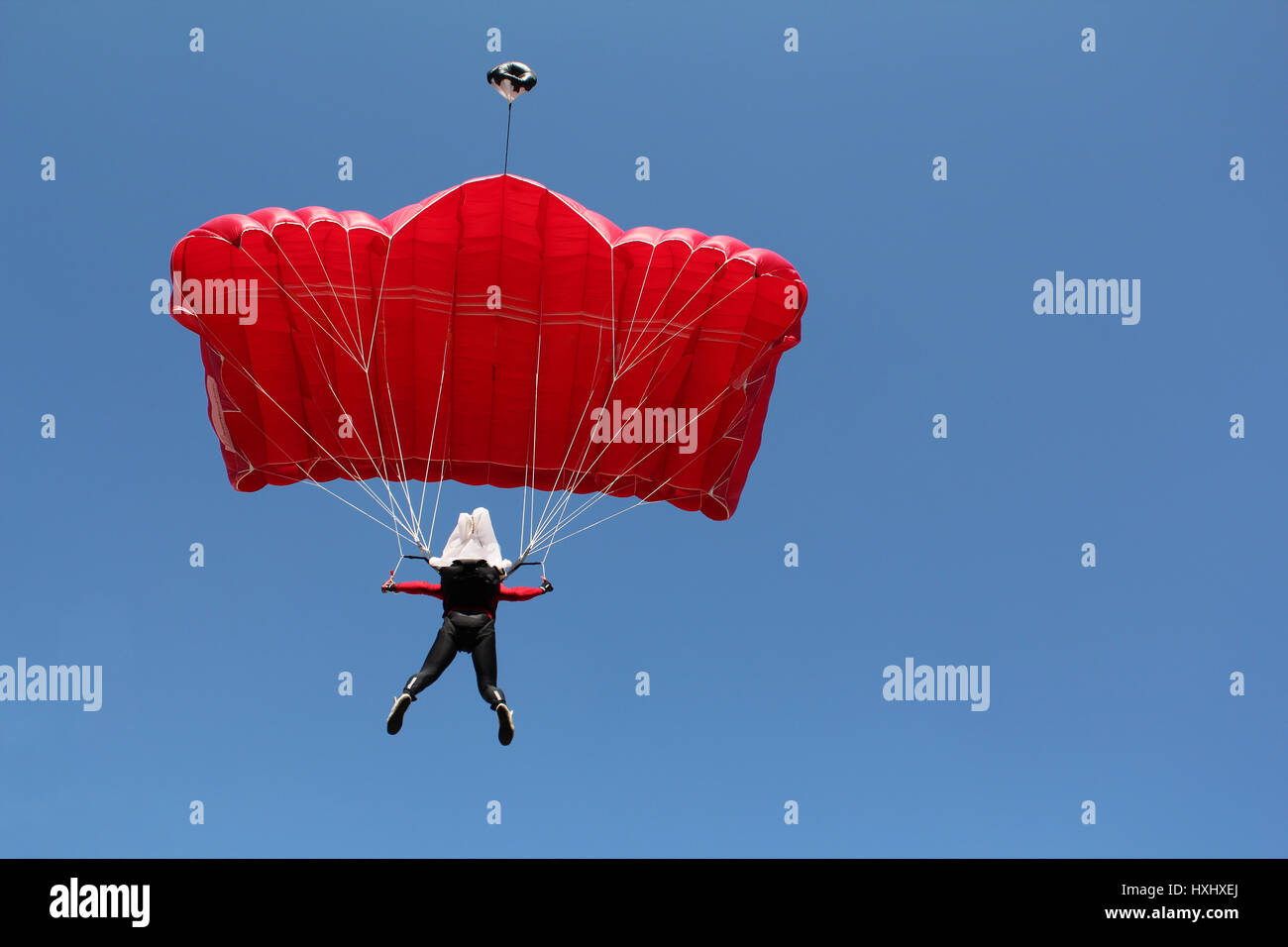 parachutist with red parachute on blue sky Stock Photo Alamy