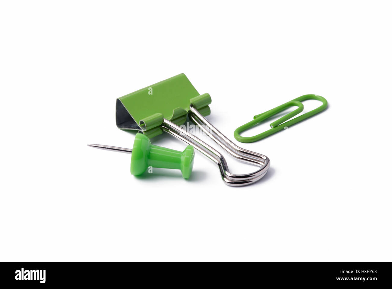 Green pushpin and paperclips on a white background. Stock Photo