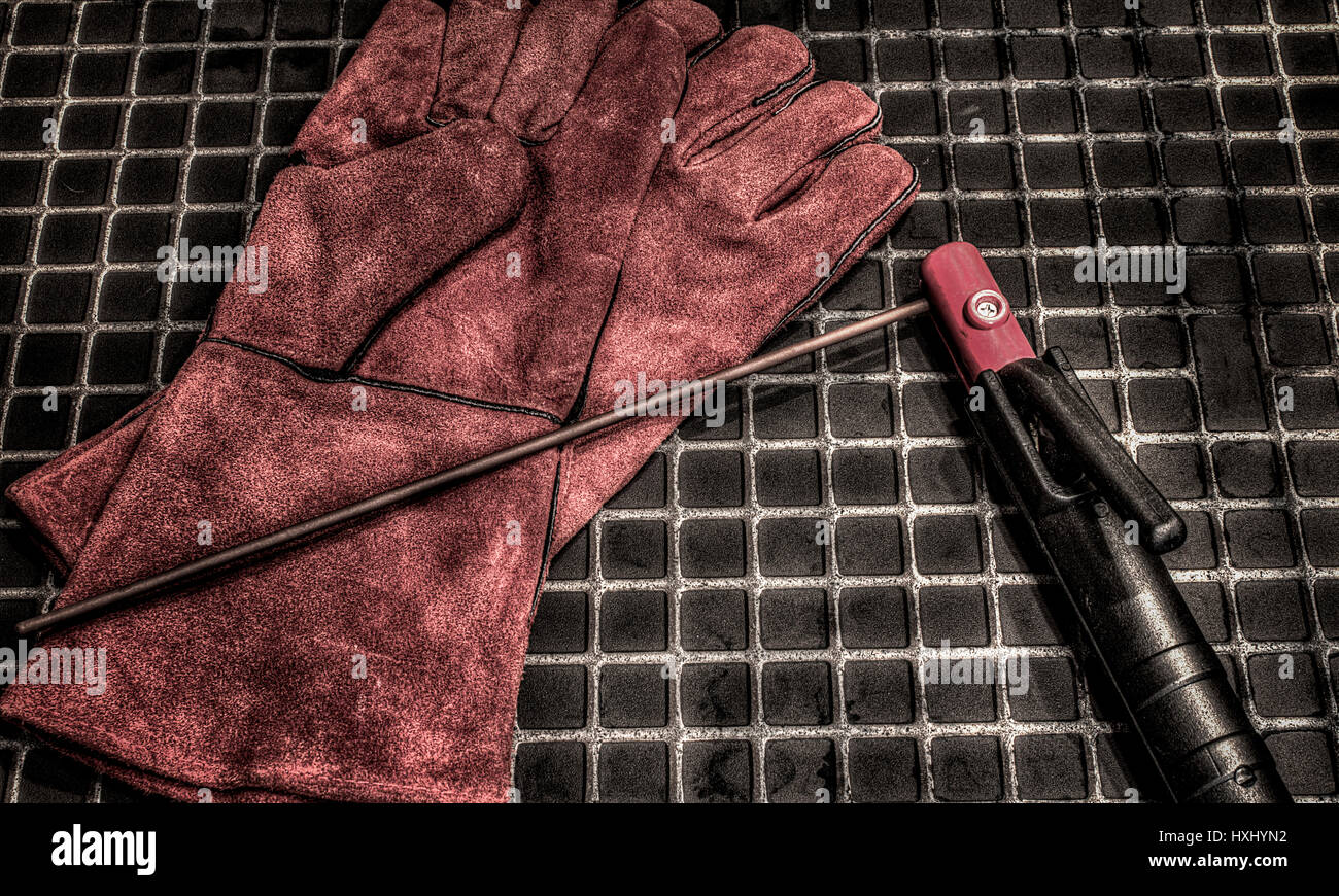 Gloves for welders.Orange leather gloves and electrodes for welding