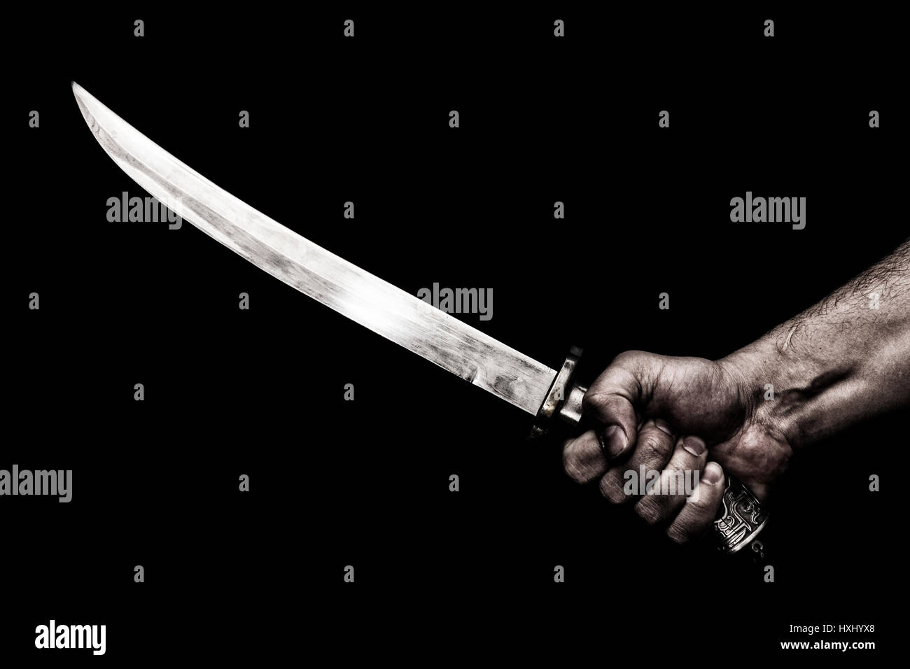 hand holding knife against plank wood Stock Photo