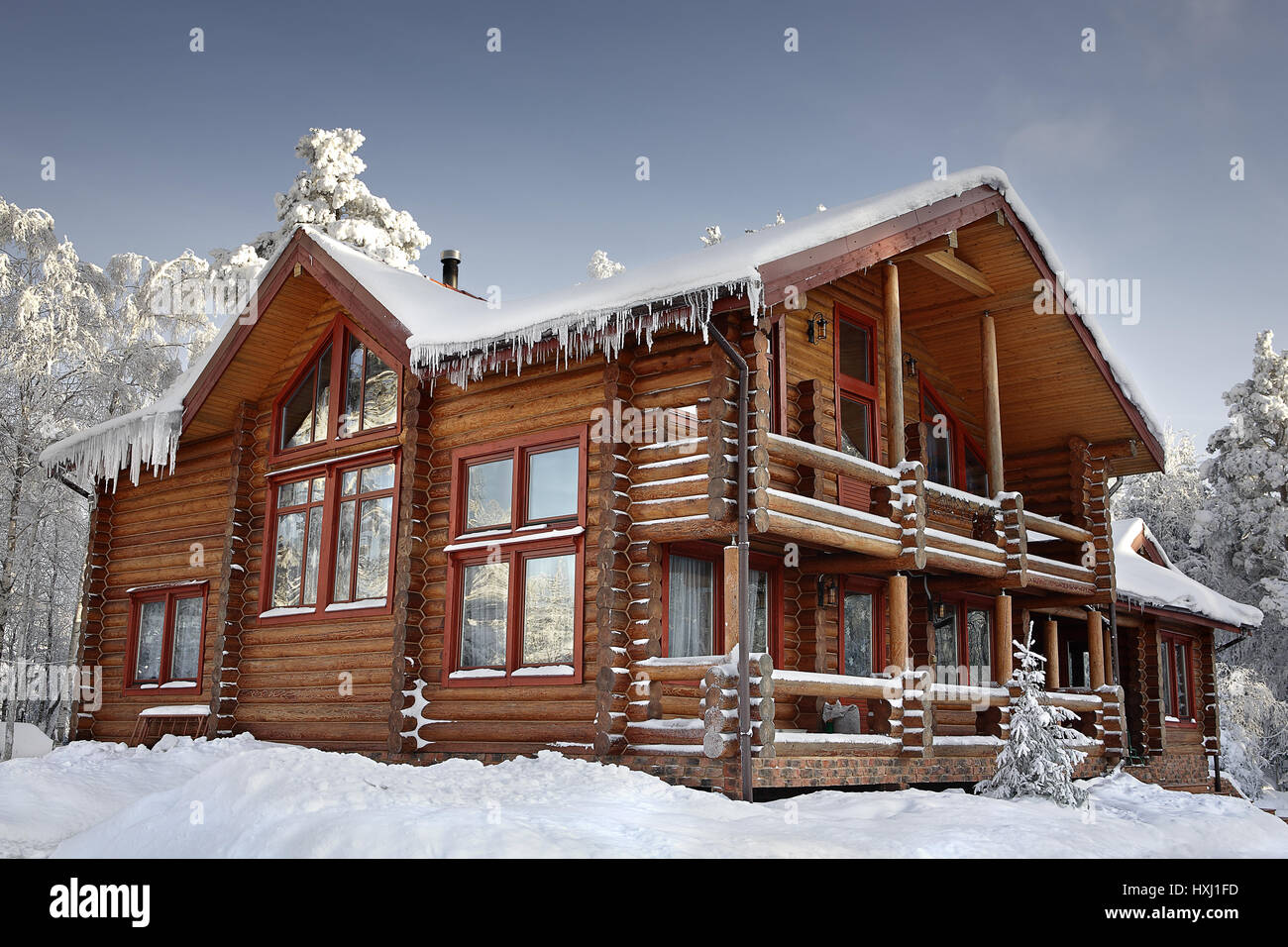 Log cabin with large windows, balcony and porch, modern house design, snowy  winter, sunny day Stock Photo - Alamy