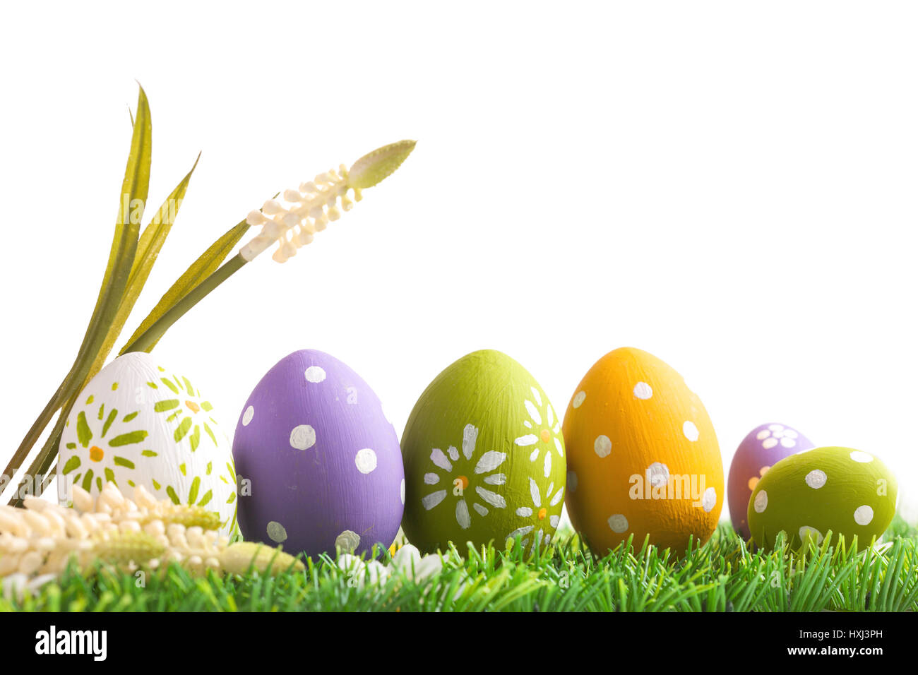 Bunch of easter eggs in pastel colors on grass, isolated on white background Stock Photo