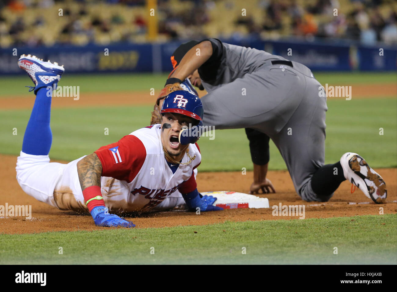 March 20, 2017: Puerto Rico infielder Javier Baez #9 yells for a challenge  after being called out trying to steal third on a tag by Netherlands  infielder Xander Bogaerts #1 in the