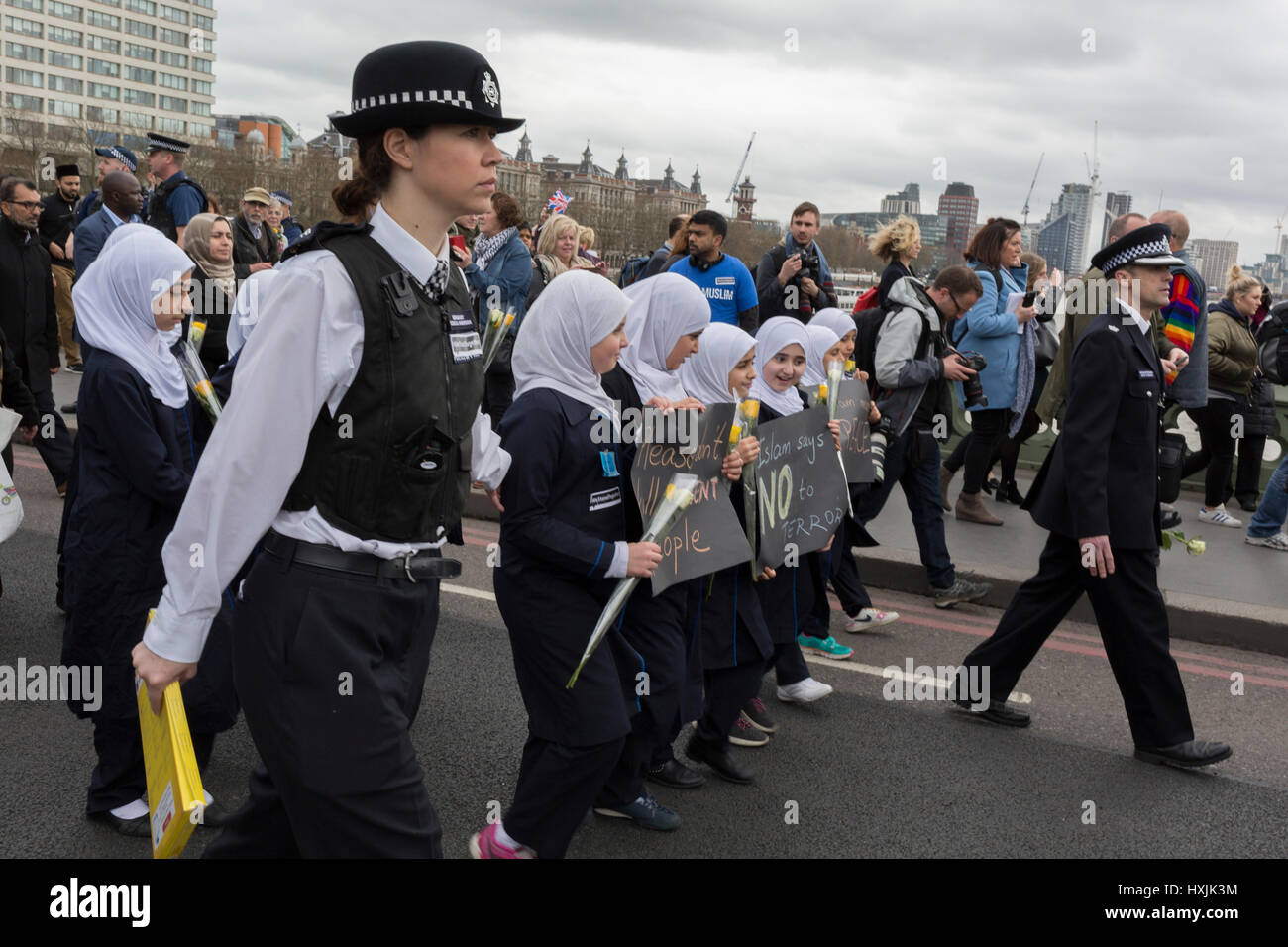 London, UK. 28th March 2017. Londoners and police gather on Westminster Bridge, the scene of the Terrorist attack 7 days ago in which 4 people died and others severely injured, on 29th March 2017, London, England. Hundreds crossed the Thames in a silent vigil to commemorate those who died at 2.40pm when Khalid Masood drove into crowds on the bridge before stabbing a police officer at the nearby Palace of Westminster. The crowds fell silent, many bowing their heads, among them were dozens of young Muslim children and members of the Ahmadiyya community. © Richard Baker/Alamy Live News Stock Photo