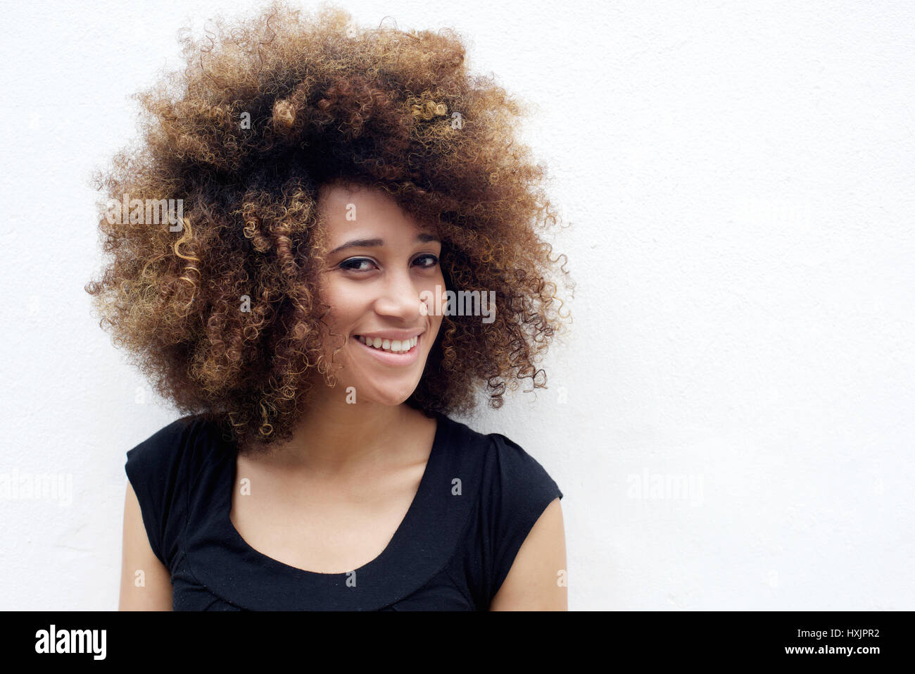 Portrait of smiling young african american woman standing against white ...
