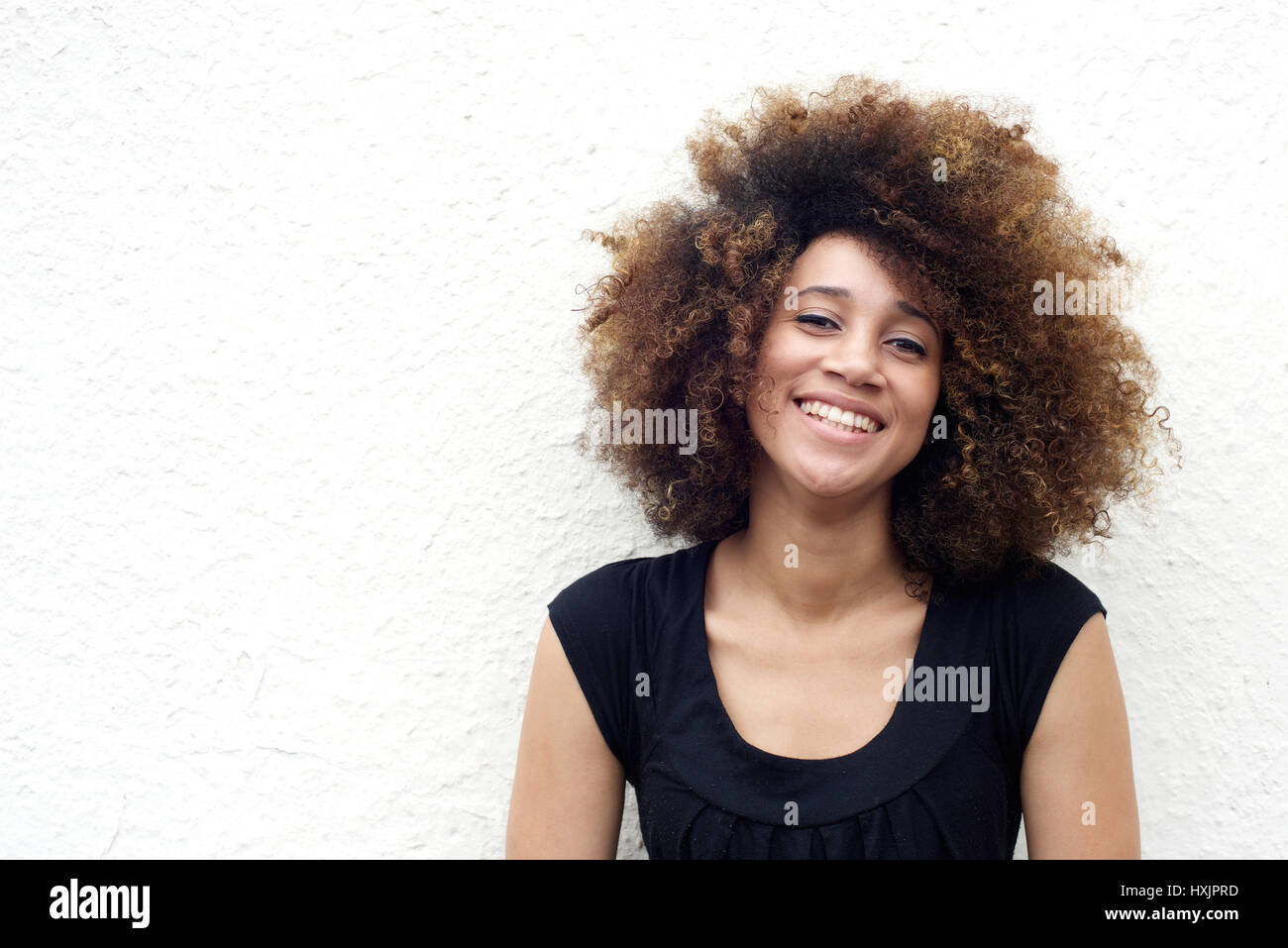 Portrait of young african woman smiling against white background Stock ...