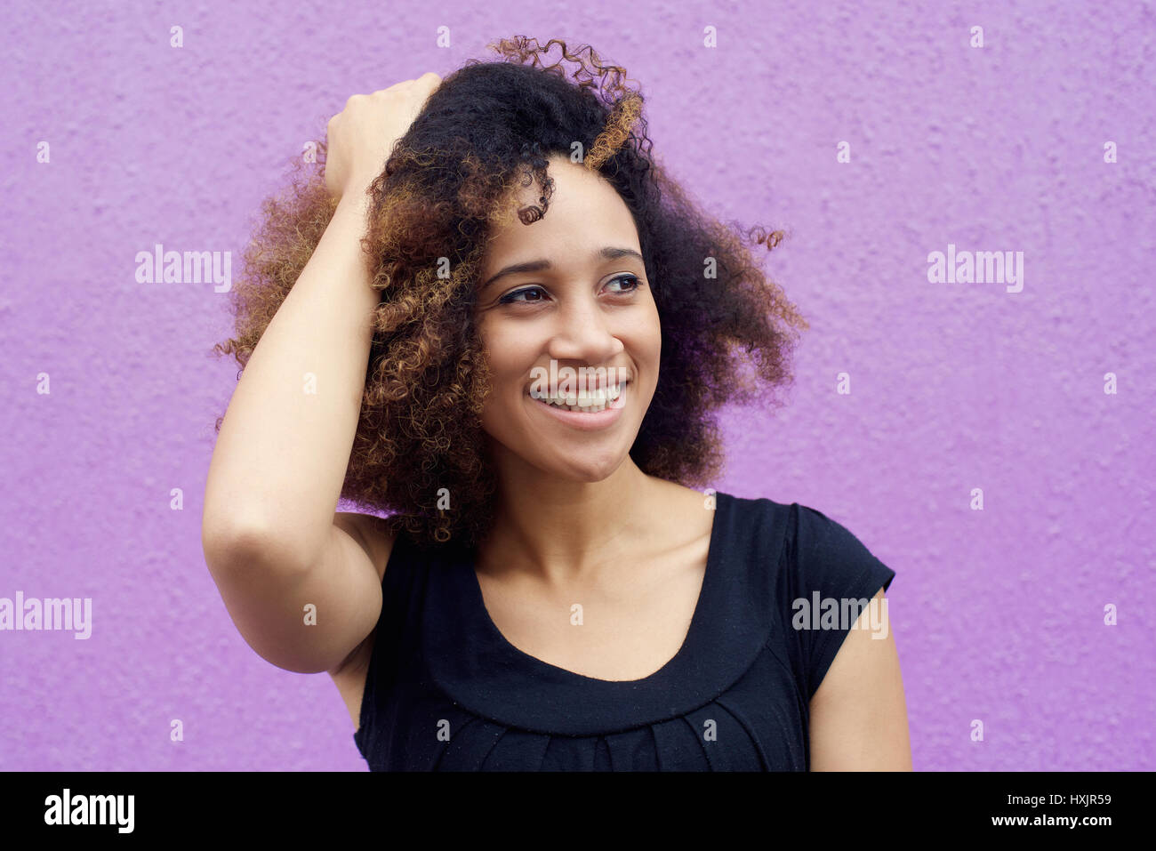 Close up young black woman smiling with hand in hair Stock Photo - Alamy