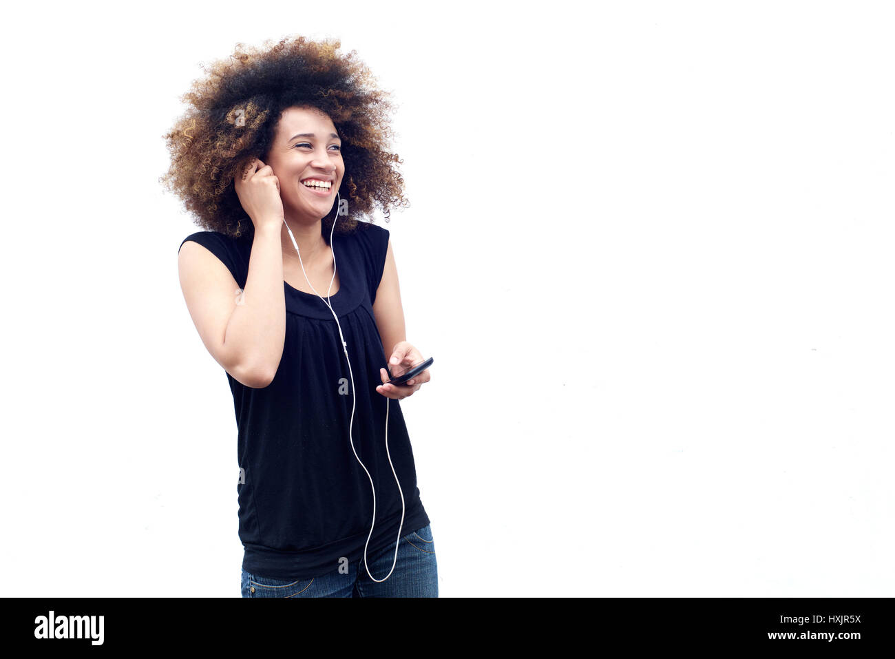 Portrait of laughing woman with cell phone and earphones Stock Photo