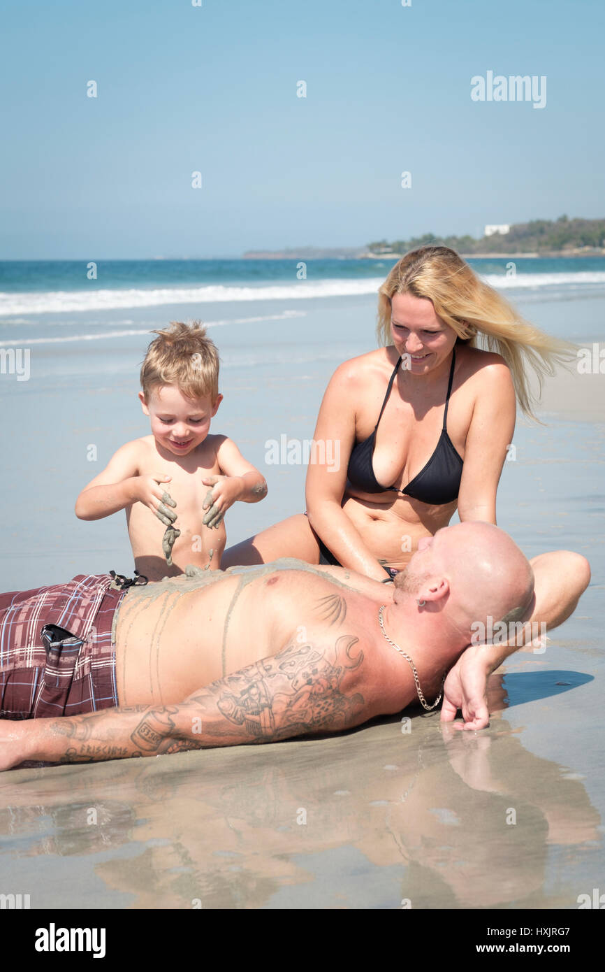 Beach family fun, toddler child playing with sand on the beach Stock Photo