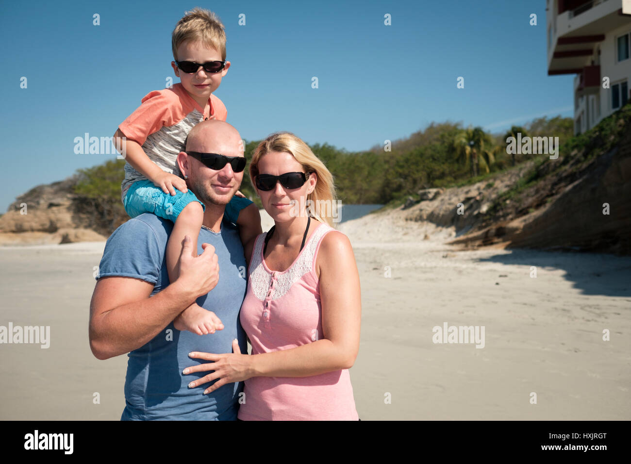 Family of 3 on the a beach, father - mother - toddler child Stock Photo