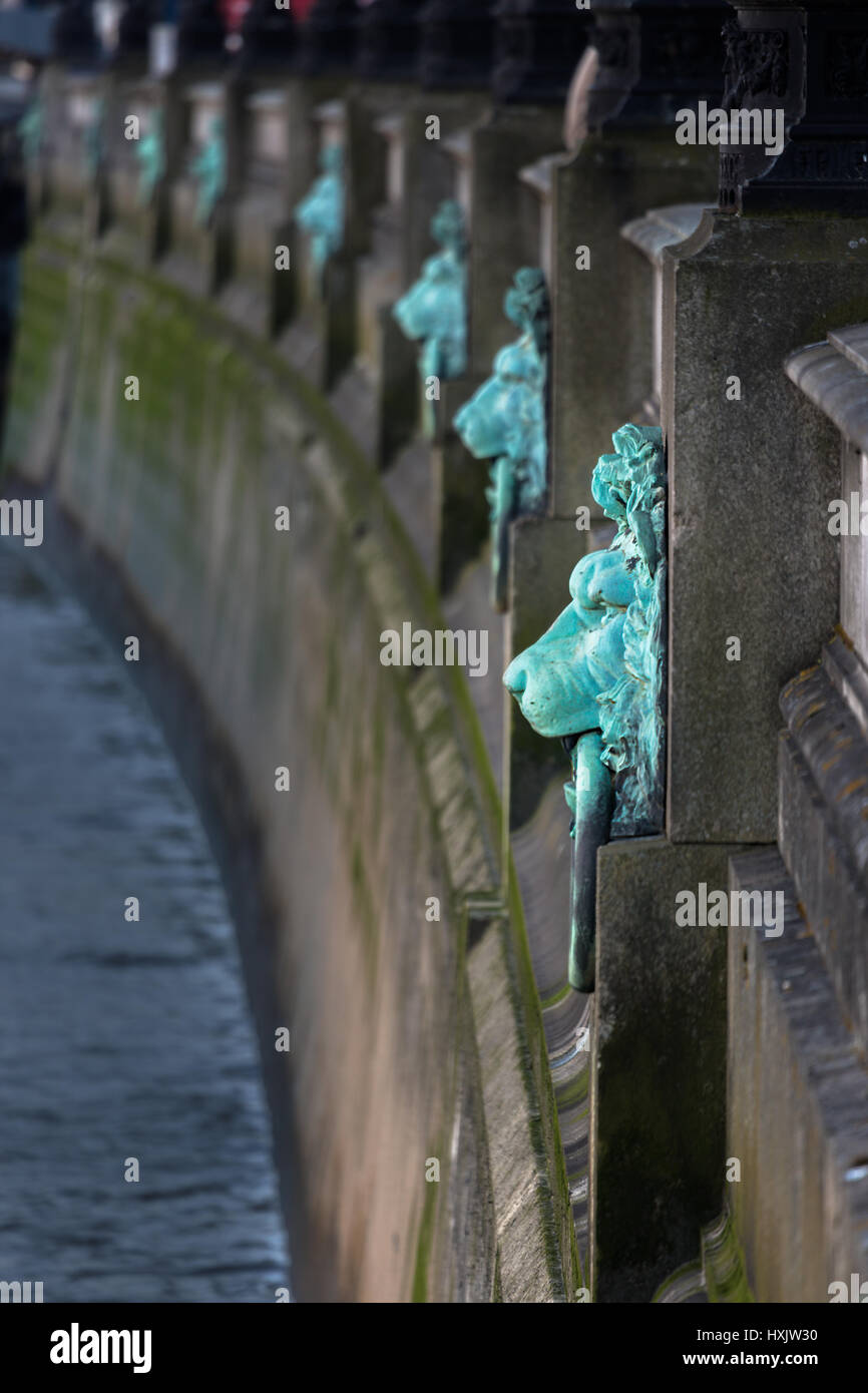 Decorative mooring rings in the shape of lions head along the embankment of the River Thames, London, England, United Kingdom. Act as flood markers. Stock Photo