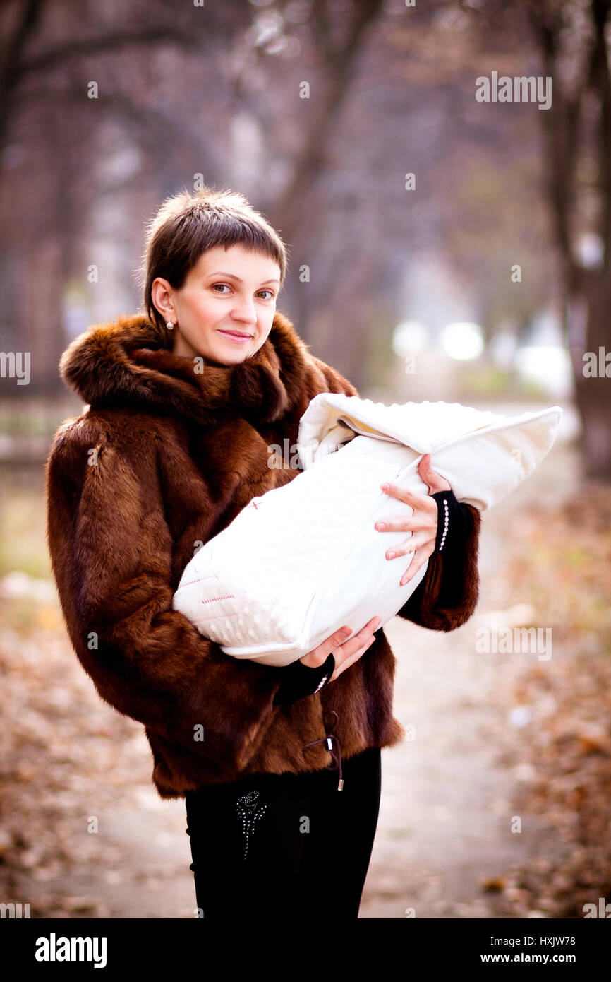 mother holding baby on arms, wrapped in a blanket. soft focus effect.  Stock Photo