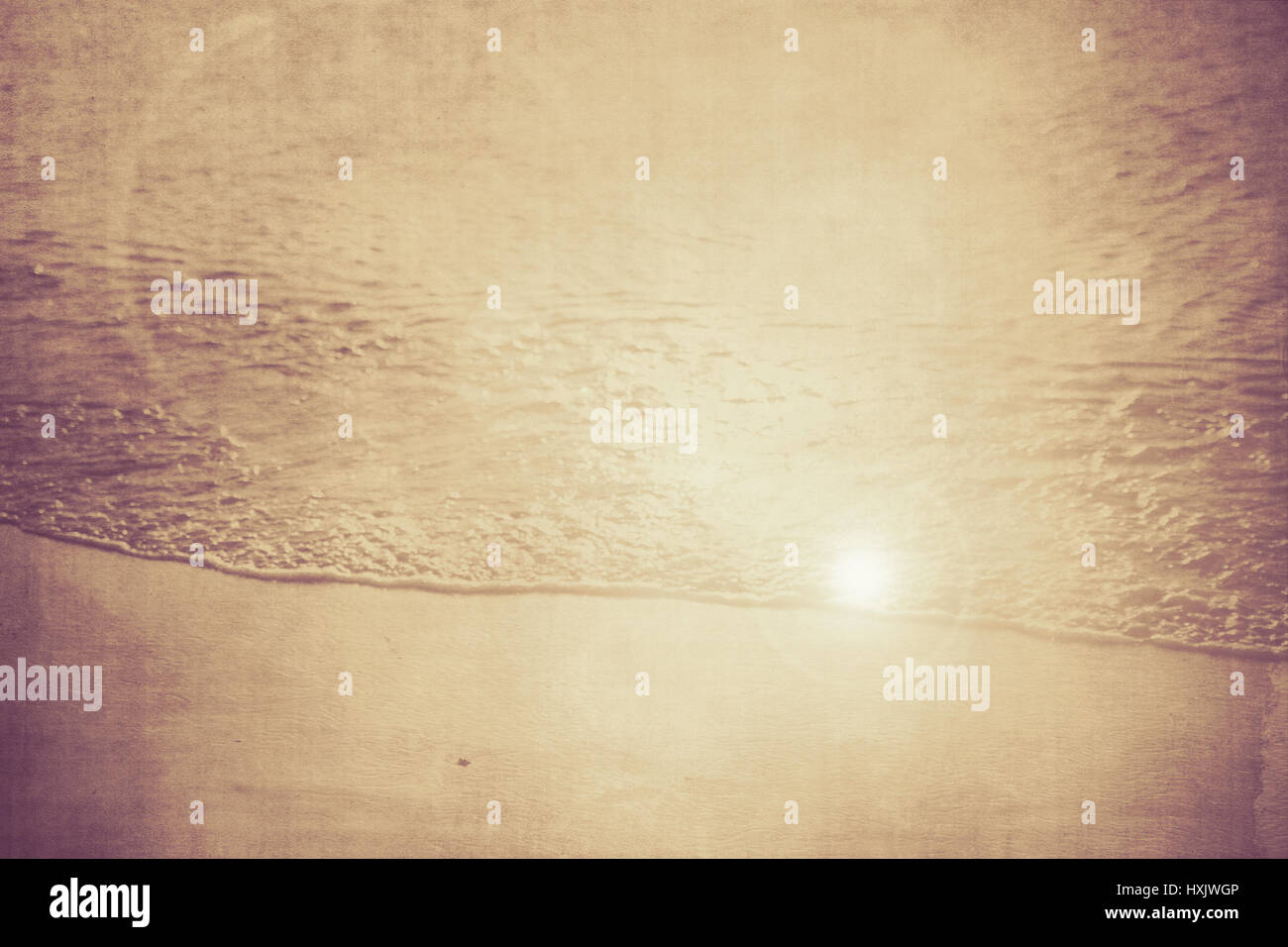Vintage textured Beach nature backdrop with ocean water, sand and sun flare Stock Photo