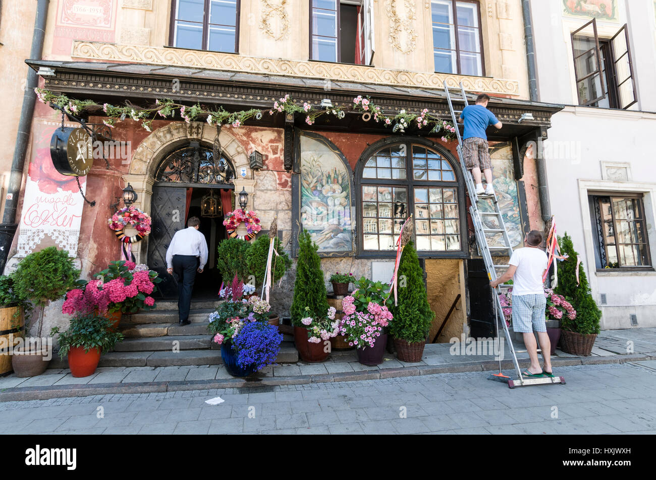 Contractors decorating a restaurant  with fresh flowers at a Polish restaurants in Warsaw's Old Town Market Place., Poland.  It  is a main square surr Stock Photo